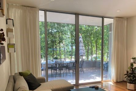 Stylish draperies and curtains half drawn on Richmond living room patio doors, providing light control